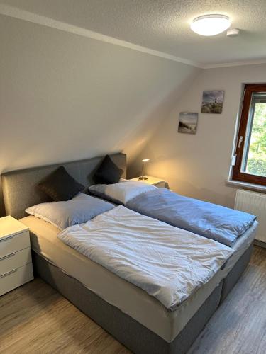 een slaapkamer met een groot bed met blauwe lakens bij Home of Oasis in Surwold