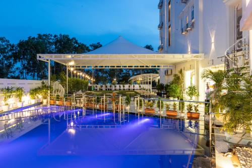 a view of a hotel pool at night at Hotel Caesars Palace in Bhopal