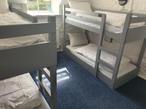 a room with three bunk beds and a window at YHA Port Eynon in Port-Eynon