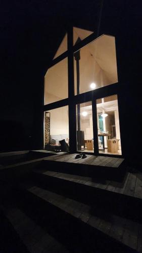 a room with a large window in the dark at Schody do wody Domek z linią brzegową Kaszuby sauna goraca balia in Roztoka