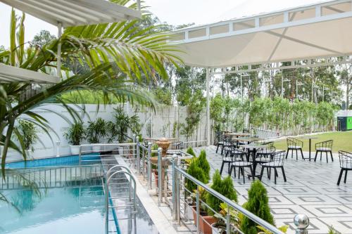 a patio with tables and chairs and a pool at Hotel Caesars Palace in Bhopal