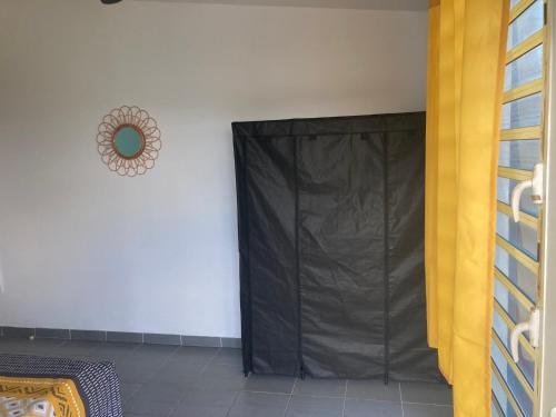 a black curtain in a room next to a wall at Central Appart in Mamoudzou