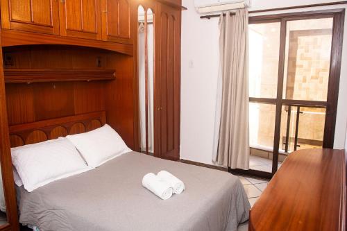 a bedroom with a bed with two towels on it at Lindo e bem localizado 3 quartos de frente p/ Mar - Praia do Forte - CF06 in Cabo Frio