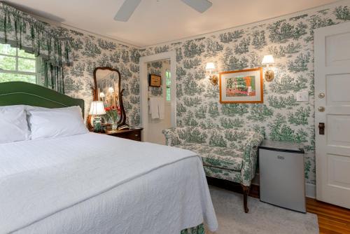 a bedroom with a bed and a chair at Pinecrest Bed & Breakfast in Asheville