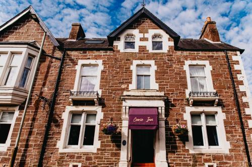 an old brick house with a purple door at Coorie Inn Restaurant and Rooms in Crieff