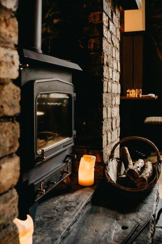 a fireplace with a basket in front of it at Coorie Inn Restaurant and Rooms in Crieff