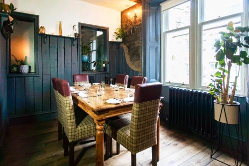 a dining room with a wooden table and chairs at Coorie Inn Restaurant and Rooms in Crieff