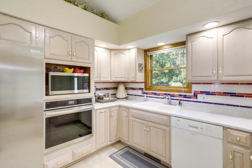 a kitchen with white cabinets and a sink and a window at Sturgis Home with Yard Less Than 1 Mi to Minnewaukan Lake in Sturgis