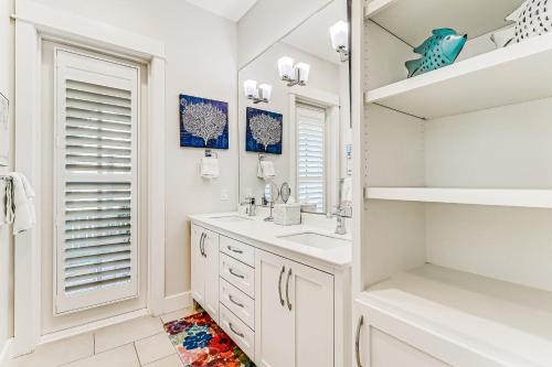 Baño blanco con lavabo y espejo en Sunset Cove at Palmilla Beach, en Port Aransas