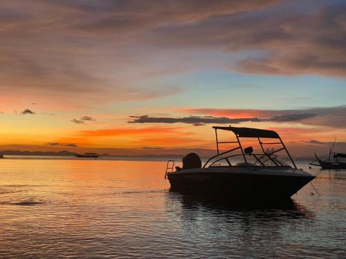 a boat sitting in the water at sunset at The Philip Ann Resort in Mabini