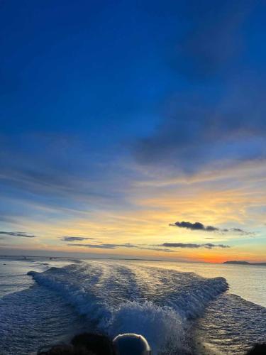 a sunset on the beach with a wave trail at The Philip Ann Resort in Mabini