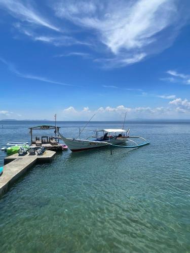 a boat is docked at a dock in the water at The Philip Ann Resort in Mabini