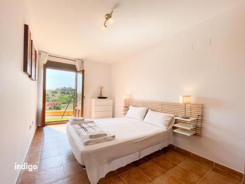 1 dormitorio con cama grande y ventana grande en HAA001) Apartamento moderno con jardín., en Ayamonte