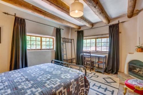 a bedroom with a bed and a fireplace at Beautiful Historic Adobe Home about 3 Mi to Taos Plaza in Taos