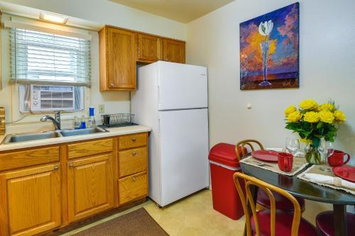 a kitchen with a white refrigerator and a table at Quaint Cody Cottage with Grill Walk to Downtown! in Cody
