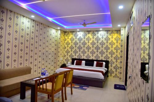 a bedroom with a bed and a couch and a table at Hotel Nexus in Lucknow