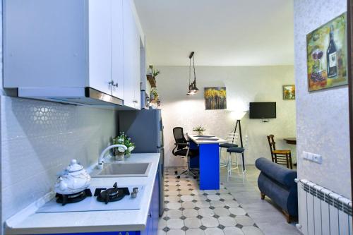 a kitchen with a sink and a table in a room at Perfect Place in Kutaisi