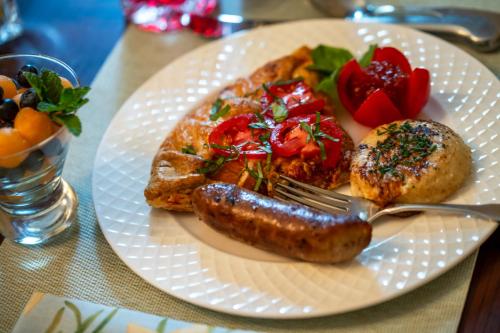 a plate of food with sausage and bread on a table at Pinecrest Bed & Breakfast in Asheville