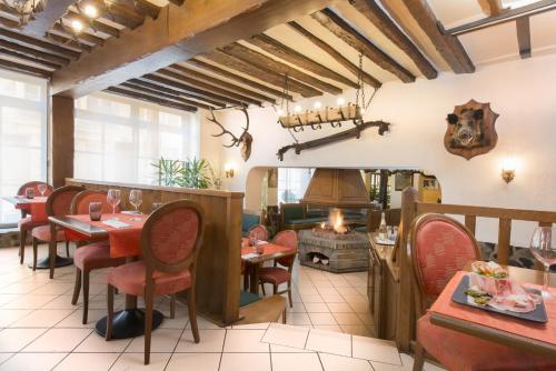 a restaurant with tables and chairs and a fireplace at Le Saint Michel in Sedan