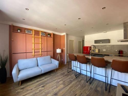 un salon avec un canapé bleu et une cuisine dans l'établissement Appartement centre-ville, Valras-Plage, chez Géraud et Séverine, à Valras-Plage