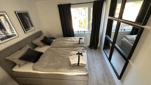 two beds in a room with a window at Top Floor Apartment Årossanden 5 A in Kristiansand