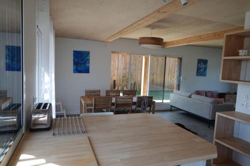 un salon avec une table en bois et un canapé dans l'établissement Maison bois Les Conches 6/8 Pers, à Longeville-sur-Mer