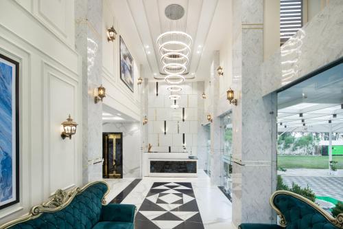 a lobby with a fireplace and blue chairs at Hotel Caesars Palace in Bhopal