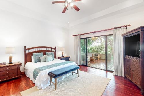 a bedroom with a bed and a flat screen tv at Villa Coral in Playa Conchal