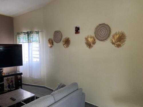 una sala de estar con sofá y algunos sombreros en la pared en Central Appart en Mamoudzou