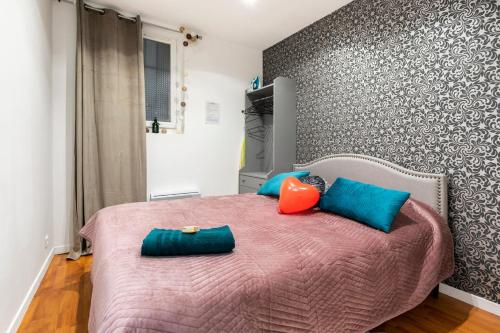 - une chambre avec un lit rose et des oreillers bleus dans l'établissement Chic 2 pièces, épuré & pragmatic à 5' de Paris, à Ivry-sur-Seine