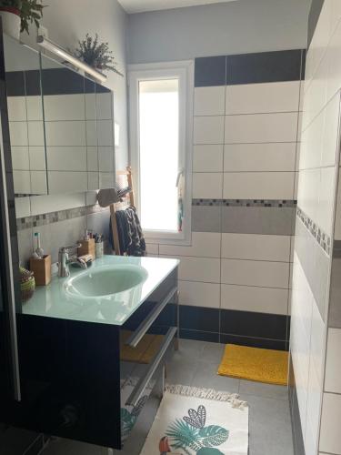 a bathroom with a sink and a mirror at Chambre avec petit dej à 2kms du centre de Nevers in Varennes Vauzelles