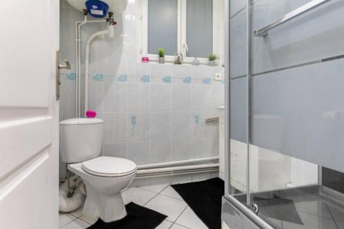 La salle de bains est pourvue d'une douche et de toilettes. dans l'établissement Chic 2 pièces, épuré & pragmatic à 5' de Paris, à Ivry-sur-Seine