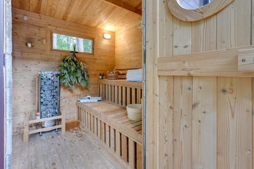 Cabaña de madera con banco y ventana en Magical Metamora Cottage with Fire Pit, Pond, Deck!, en Metamora