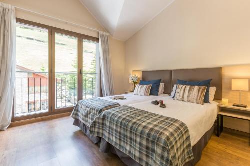a bedroom with a large bed and a large window at Pierre & Vacances Andorra Bordes d’Envalira in Bordes d´Envalira 