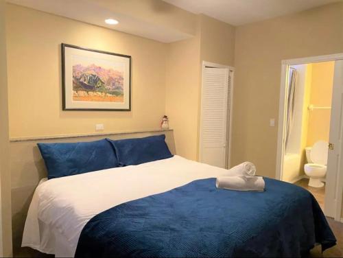 Un dormitorio con una cama azul y blanca y un aseo en Mountain View Vacation Villa Main Floor Unit, No Stairs, en Fairmont Hot Springs