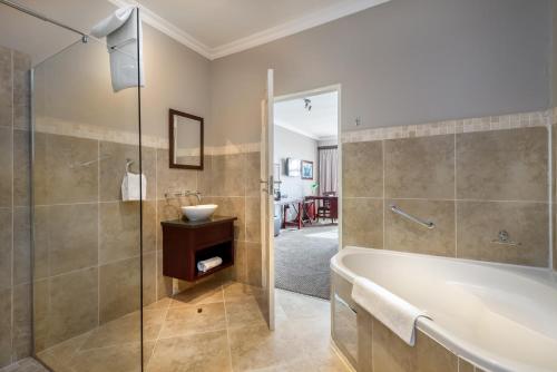 ein Bad mit einer Badewanne, einer Dusche und einem Waschbecken in der Unterkunft ANEW Hotel Highveld Emalahleni in Witbank