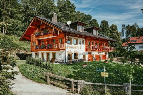 een groot houten huis bovenop een heuvel bij Landhotel Berger in Ainring