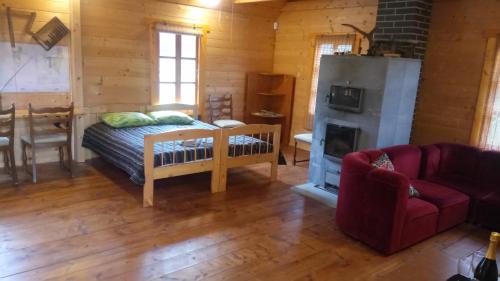 a living room with a bed and a fireplace at Loopre Vesiveski puhketalu in Loopre