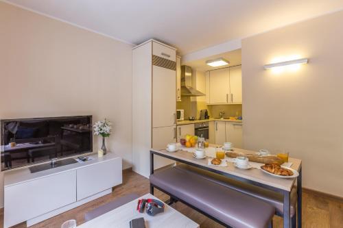 a living room with a table and a kitchen at Pierre & Vacances Andorra Bordes d’Envalira in Bordes d´Envalira