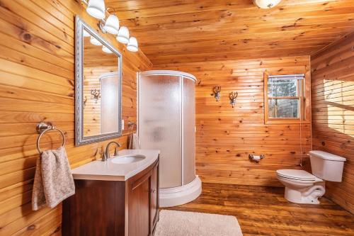 baño con aseo y lavamanos en una cabaña de madera en Horizon Shine, en McHenry