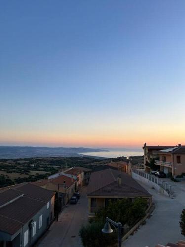 a view of a small town at sunset at Casa Smeralda - Piscina e vista sul Mare! in Trinità dʼAgultu