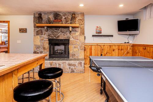 a living room with a stone fireplace and two bar stools at Sunkissed Lodge in McHenry