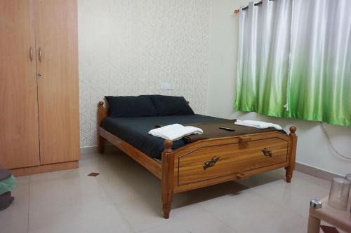 1 dormitorio con 1 cama con cortina verde en VPR Cottage, en Yelagiri