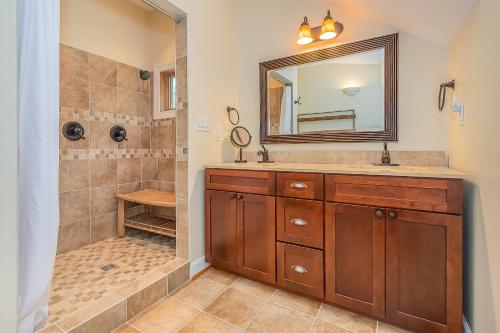 a bathroom with a shower and a sink and a mirror at Sunset Cove in Swanton