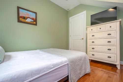 a bedroom with a white bed and a dresser at Sunset Cove in Swanton