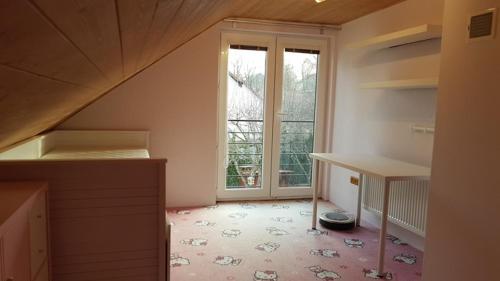 an attic room with a staircase and a large window at Chatička na Lipce, Železné hory, Sečská přehrada in Horní Bradlo