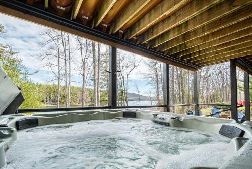 a hot tub in a room with a large window at Stone Crest in Oakland