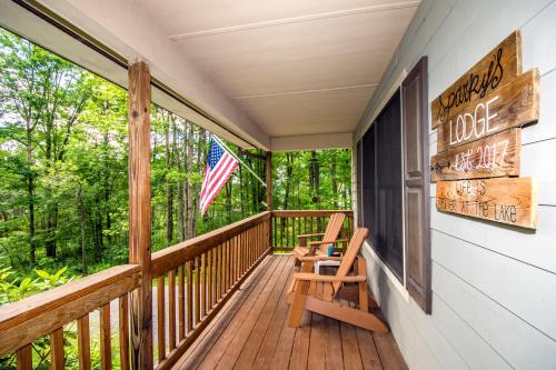 a porch with two chairs and an american flag at Sparkys Lodge in McHenry