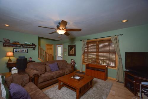 a living room with a couch and a ceiling fan at Sparkys Lodge in McHenry