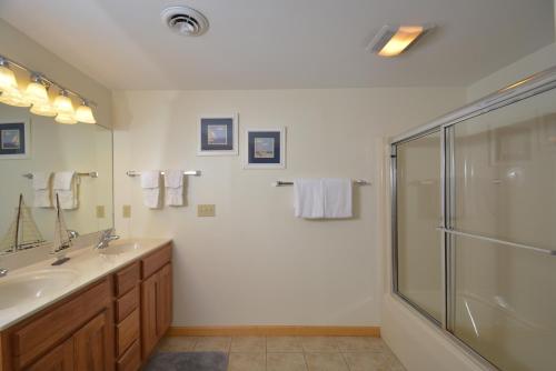 a bathroom with a glass shower and a sink at Sparkys Lodge in McHenry